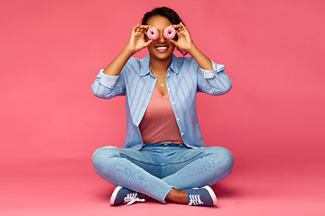 Image showing happy african american woman with eyes of donuts