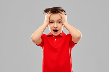 Image showing shocked little boy in red t-shirt touching head