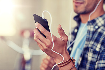 Image showing man with earphones and smartphone listening music