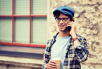 Image showing man with coffee calling on smartphone in city