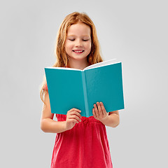 Image showing smiling red haired girl reading book