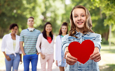 Image showing smiling teenage girl with red heart outdoors