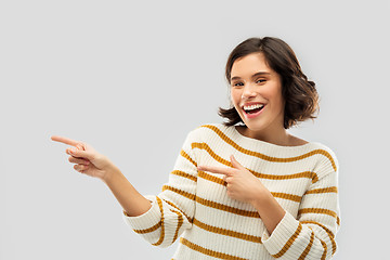 Image showing happy smiling woman pointing fingers to something