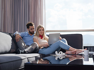 Image showing couple relaxing at  home using laptop computer