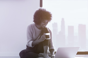 Image showing black woman in the living room on the floor