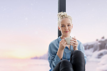 Image showing woman drinking coffee and using laptop at home