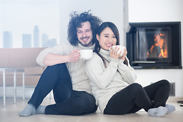 Image showing happy multiethnic couple  in front of fireplace