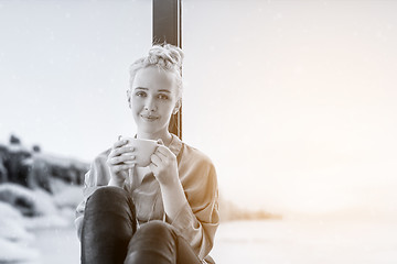 Image showing woman drinking coffee and using laptop at home