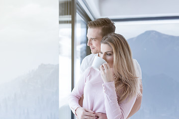 Image showing young couple enjoying morning coffee by the window