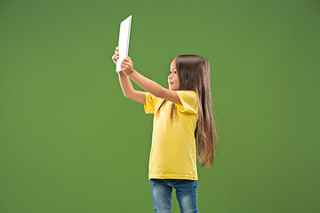 Image showing Teen girl with laptop. Love to computer concept. Attractive female half-length front portrait, trendy green studio backgroud.