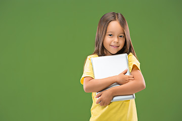 Image showing Teen girl with laptop. Love to computer concept. Attractive female half-length front portrait, trendy green studio backgroud.