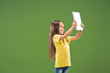 Image showing Teen girl with laptop. Love to computer concept. Attractive female half-length front portrait, trendy green studio backgroud.