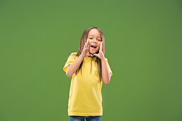 Image showing Isolated on blue young casual teen girl shouting at studio