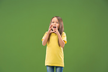 Image showing Isolated on blue young casual teen girl shouting at studio