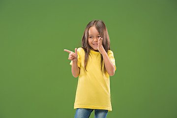 Image showing The young teen girl whispering a secret behind her hand