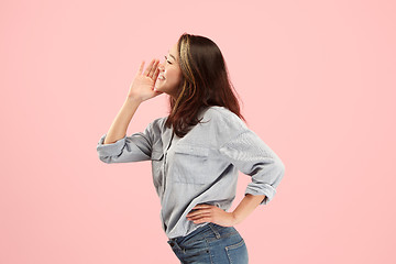 Image showing Isolated on pink young casual woman shouting at studio