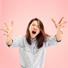Image showing The young emotional angry woman screaming on pink studio background