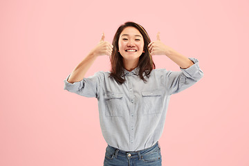 Image showing The happy business woman standing and smiling against pink background.