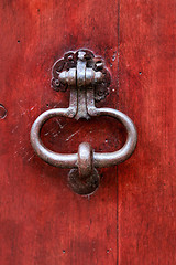 Image showing Vintage bright red wooden door with metallic knocker