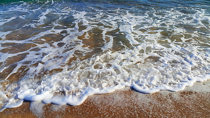 Image showing Sea wave with white foam in the coastal sand