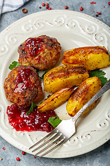 Image showing Meat cutlets and baked potatoes with lingonberry sauce.
