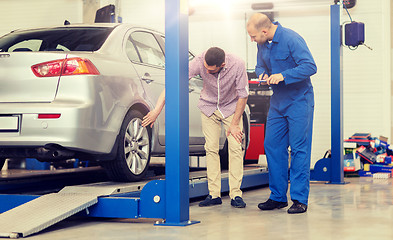 Image showing auto mechanic with clipboard and man at car shop