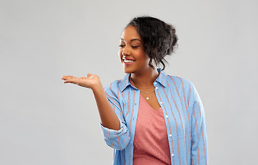 Image showing happy african woman holding something on hand