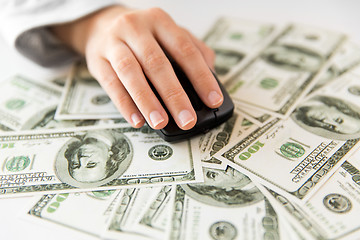 Image showing close up of hand with computer mouse on money