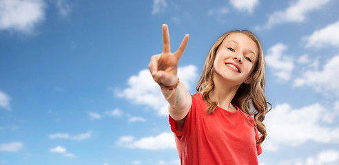 Image showing smiling teenage girl showing peace over sky