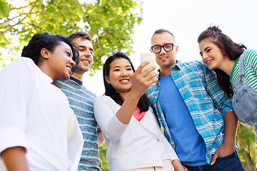 Image showing happy friends with smartphone at summer park