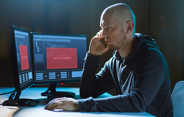 Image showing hacker with no access on computer calls on cell