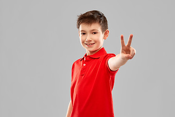 Image showing smiling boy in red t-shirt showing peace gesture