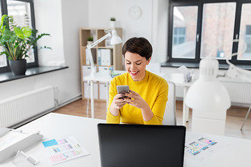 Image showing smiling ui designer using smartphone at office