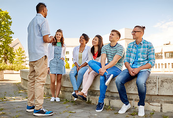 Image showing happy international friends talking in city