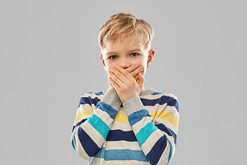 Image showing shocked little boy closing his mouth by hands