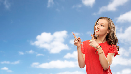 Image showing smiling teenage girl pointing fingers to something