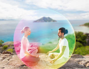 Image showing couple doing yoga in lotus pose with rainbow aura