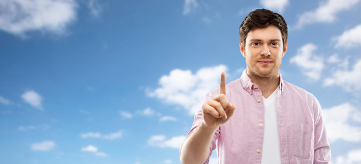 Image showing young man showing one finger over sky