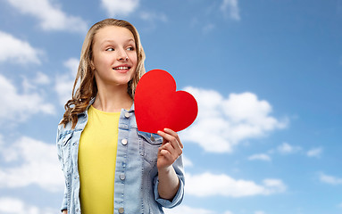 Image showing smiling teenage girl with red heart over sky