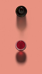 Image showing Red wine in a glass with opened bottle with shadows.