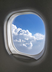 Image showing Airplane window with picture of sky cloudy aerial view.