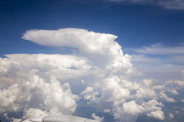 Image showing View frome plane onto wing and white clouds and sky.