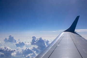 Image showing Plane wing on a blue sky cloudy background