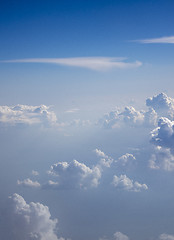 Image showing Sun light through clear blue sky with fluffy clouds.