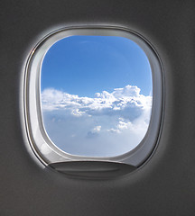 Image showing View of cloudy blue clear sky through airplane porthole.