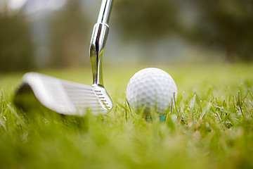 Image showing Golf ball on tee in front of driver