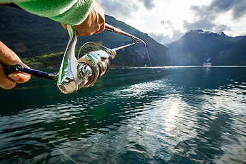 Image showing Woman fishing on Fishing rod spinning in Norway.