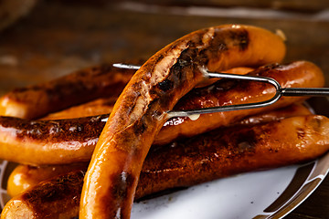 Image showing Grilled sausages on wooden board