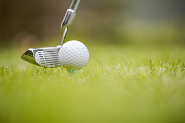 Image showing Golf ball on tee in front of driver