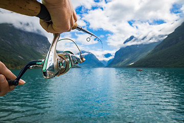 Image showing Woman fishing on Fishing rod spinning in Norway.